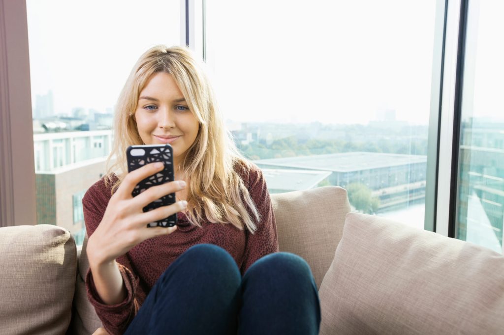 Women on couch looking at mobile phone