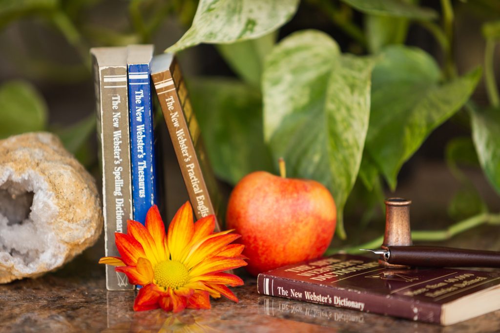 Desk with books, apple, flower